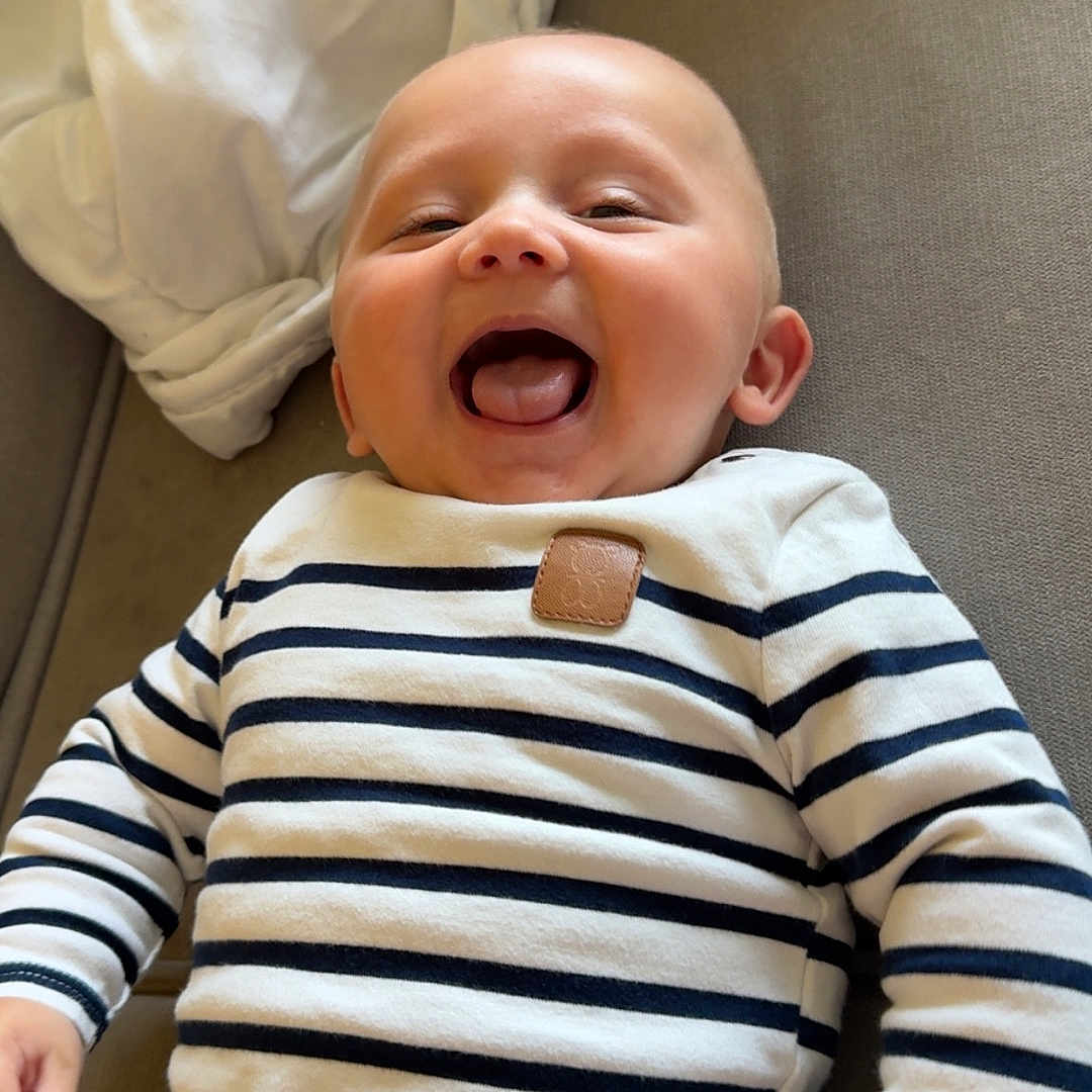 Ezeckiel participe au concours pour gagner de l'argent avec cette photo : baby, child, clothing, couch, cute, face, hand, happy, head, indoor, infant, joy, mouth, person, portrait, skin, sleeve, smile, striped_shirt, young