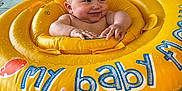Ezeckiel participe au concours pour gagner de l'argent avec cette photo : baby, inflatable_ring, swimming_pool, water, child, toddler, hand, manicure, float, yellow, smile, play, fun, indoor_pool, tiles, person, summer, splash, cute, recreation