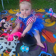 Lainee Jo joined the competition — help win amazing prizes! baby, blanket, blue_tutu, child, colorful, cute, grass, happy, minnie_mouse, outdoor, person, pink_pig, playful, portrait, red_bow, sitting, spotted_dog, stuffed_animal, toys, tutu