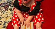 Lainee Jo joined the competition — help win amazing prizes! baby, bright_colors, celebration, child, cute, dress, face, feet, hands, happy, indoor, infant, milestone_card, person, polka_dot, portrait, red_blanket, sitting, smiling, young_child