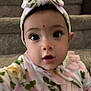 Devyani is registered to the contest to win money with this photo: apparel, baby, carpet, child, closeup, cute, expression, face, floral_pattern, green, hand, headband, headwear, indoors, infant, person, pink, portrait, stairs, young