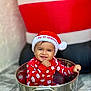baby, child, smiling, christmas_hat, red_clothing, festive, holiday, santa, metal_bucket, cute, indoor, portrait, celebration, sitting, happy, infant, holiday_season, playful, festive_outfit, smile