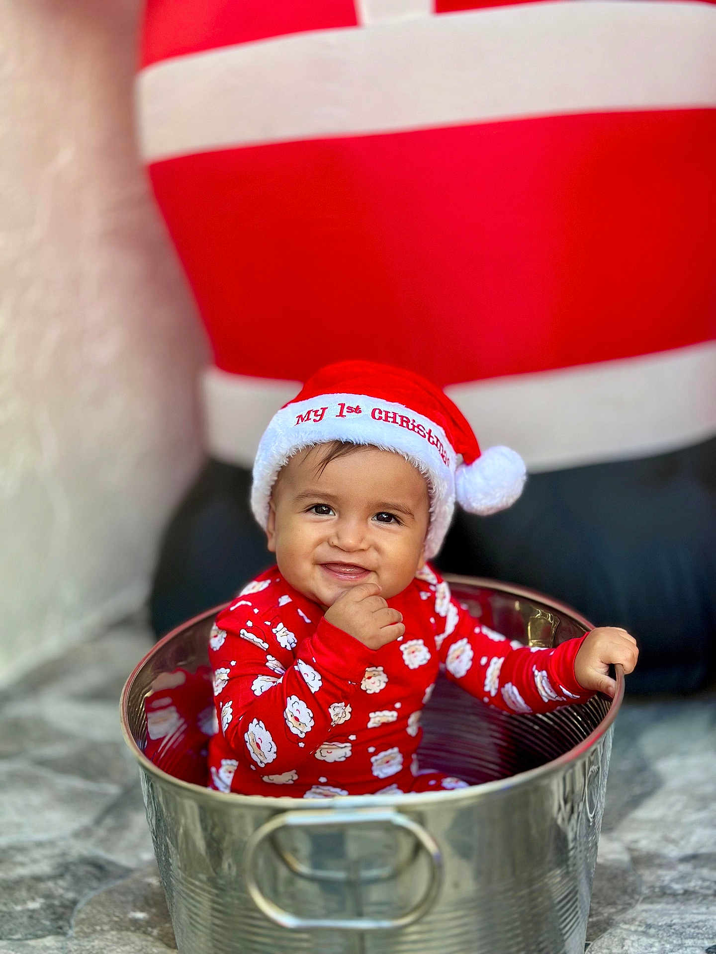 Noah is registered to the contest to win money with this photo: baby, child, smiling, christmas_hat, red_clothing, festive, holiday, santa, metal_bucket, cute, indoor, portrait, celebration, sitting, happy, infant, holiday_season, playful, festive_outfit, smile