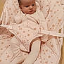 baby, infant, bouncer, pajamas, star_pattern, cloth, seat, child, indoors, floor, cute, small, resting, soft, comfort, young, person, face, head, legs