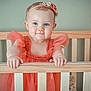 Jessie joined the competition — help win amazing prizes! baby, child, girl, crib, wood, dress, headband, flower, smile, hands, blue_eyes, portrait, indoor, furniture, toy, pink, cute, toddler, happy, person