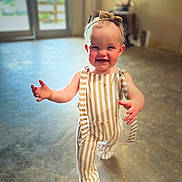 Jessie joined the competition — help win amazing prizes! toddler, child, smiling, walking, indoor, striped_overalls, headband, baby, happy, person, floor, light, shadow, blurry_background, cute, portrait, young_child, clothing, fashion, playful