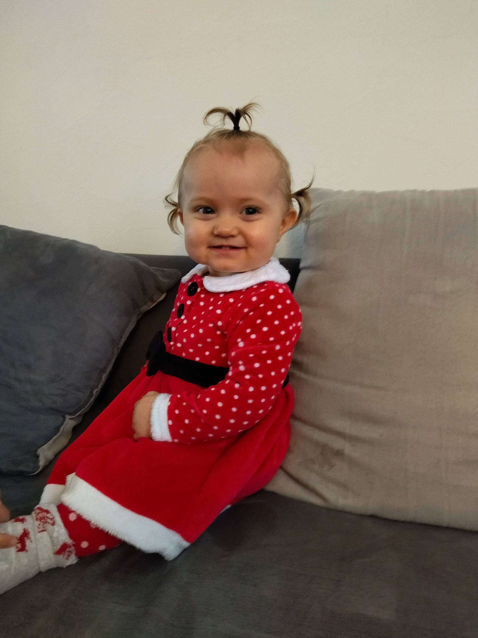 Zélia participe au concours pour gagner de l'argent avec cette photo : baby, baby_toddler_clothing, child, comfort, couch, dress, face, floor, flooring, formal_wear, human_leg, jewellery, joy, neck, outerwear, pattern, person, skin, sleeve, smile