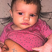 Wrenlee is registered to the contest to win money with this photo: baby, infant, child, portrait, sitting, pink_outfit, polka_dots, serious_expression, face, eyes, hair, hands, adult_arm, tattoos, indoor, close_up, flash_photography, blanket, caregiver, family