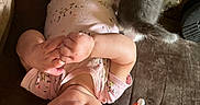 Wrenlee is registered to the contest to win money with this photo: baby, infant, child, portrait, upside_down, couch, cat, stuffed_animal, toy, bottle, onesie, pink_clothing, hands, feet, smiling, indoors, living_room, furniture, pet, playful