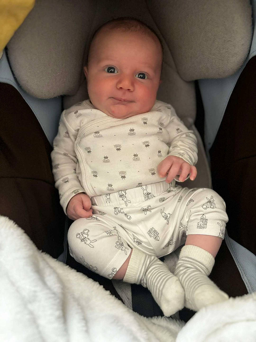 Théo participe au concours pour gagner de l'argent avec cette photo : baby, baby_products, baby_toddler_clothing, car_seat, cheek, child, comfort, elbow, eye, foot, human_leg, knee, lap, pattern, person, sitting, skin, sleeve, sock, thigh