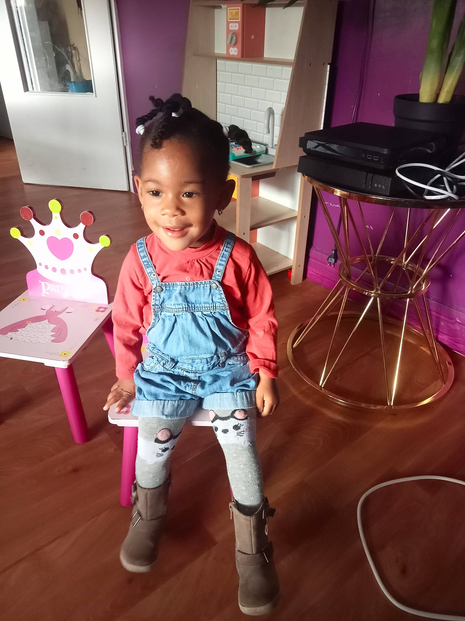 Thaina a rejoint le concours — aidez-le/la à gagner de superbes lots ! baby, baby_toddler_clothing, chair, child, event, floor, flooring, fun, happy, hardwood, joy, magenta, party_supply, person, pink, play, purple, room, sitting, smile