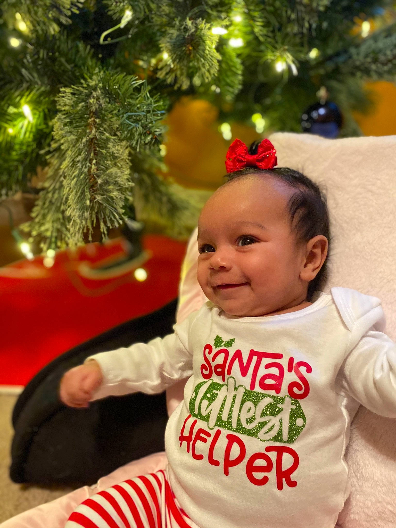 Giada is registered to the contest to win money with this photo: baby, baby_toddler_clothing, christmas_ornament, christmas_tree, eye, face, facial_expression, green, hair, hairstyle, happy, head, holiday_ornament, human_body, joy, person, plant, skin, sleeve, smile