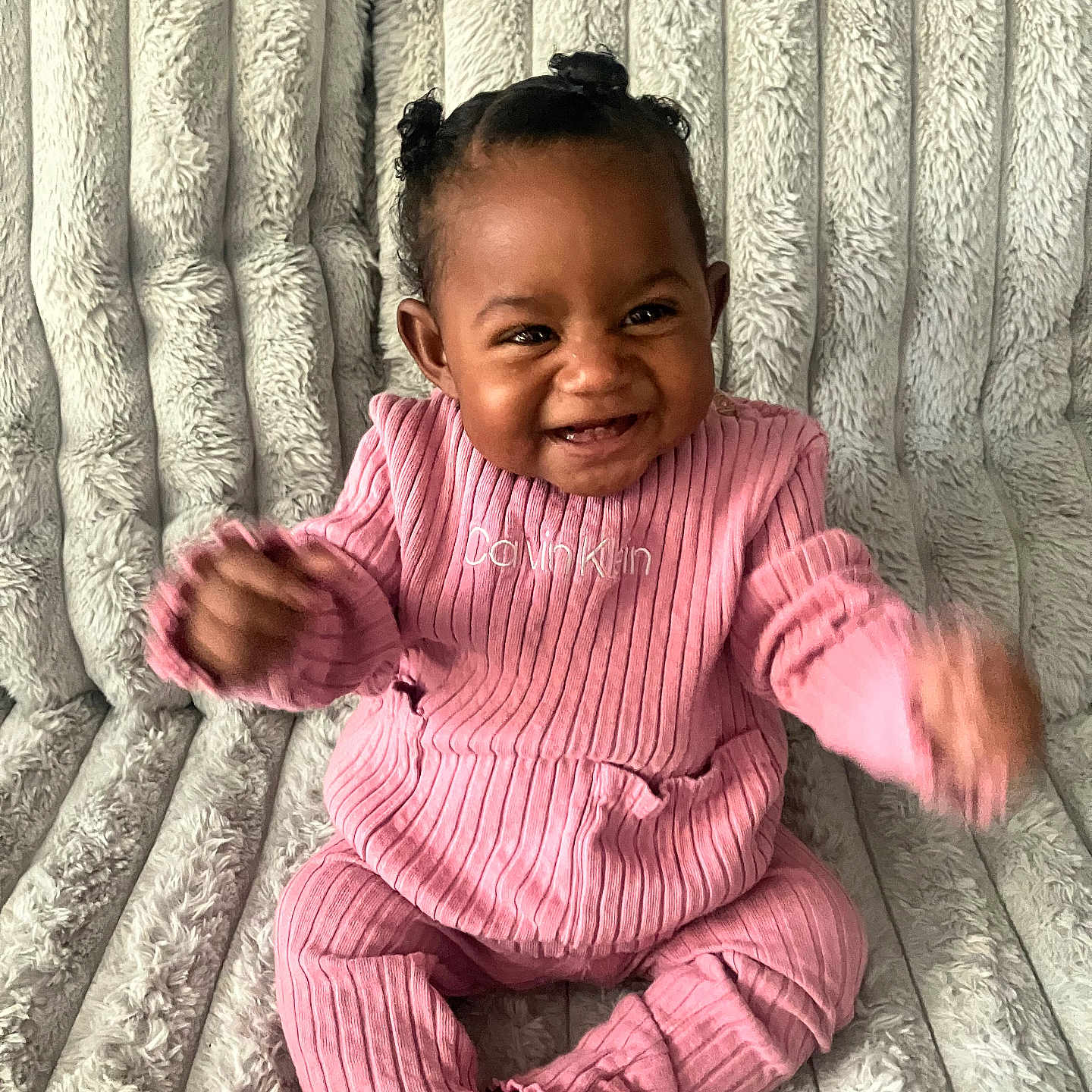 Akiyra is registered to the contest to win money with this photo: baby, baby_girl, celebration, child, cozy, cute, face, fuzzy_blanket, hair_buns, happy, indoors, infant, pink_clothing, portrait, ribbed_outfit, sitting, smiling, sock, soft, texture