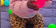 Kinzey joined the competition — help win amazing prizes! toddler, child, boots, leopard_print, leggings, pink_sweater, colorful_balls, play_mat, indoor, curious, holding, sitting, cute, baby, person, toy, bright_colors, casual_clothing, playing, expression