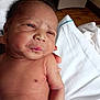 Bodhi is registered to the contest to win money with this photo: newborn, baby, infant, skin, hospital, wristband, hand, bed, sheet, wooden_floor, person, face, arm, naked, cute, sleepy, indoors, healthcare, patient, hospital_room