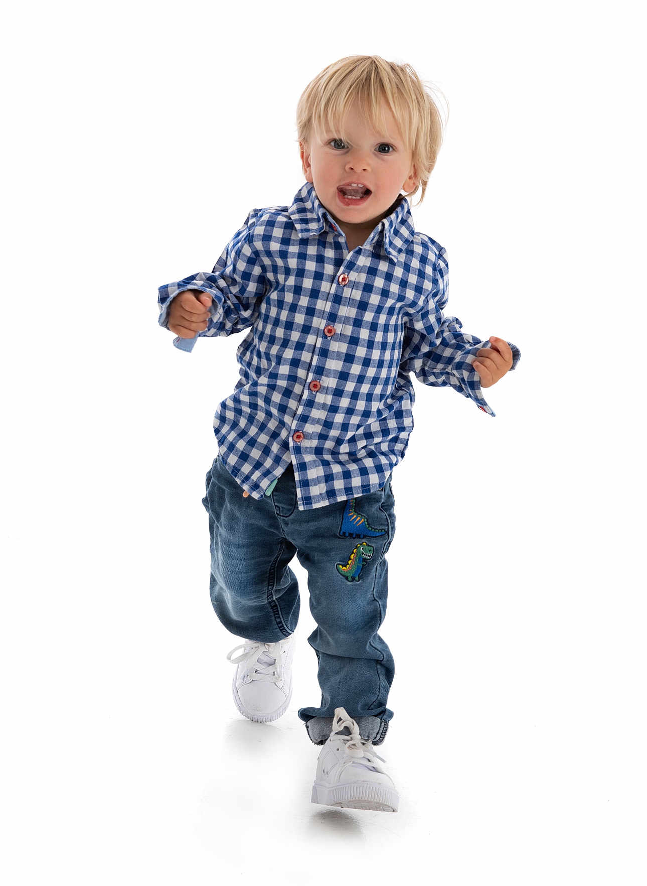 Dawson is registered to the contest to win money with this photo: toddler, child, blonde_hair, blue_checkered_shirt, jeans, dinosaur_patch, white_sneakers, walking, studio_photo, white_background, happy, curious, full_body, casual_clothing, cute, portrait, active, young_child, fashion, smiling