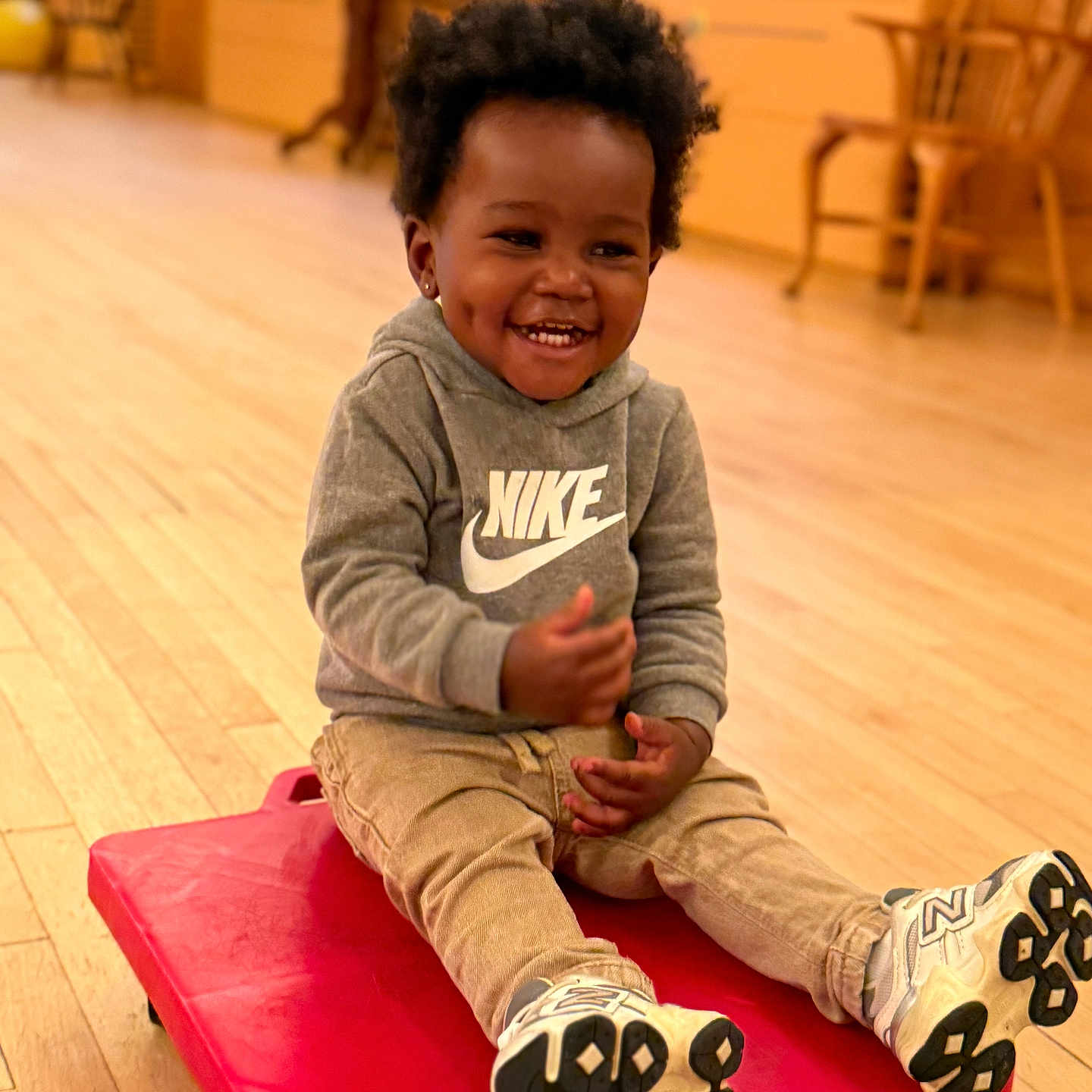 Casais joined the competition — help win amazing prizes! beige_pants, casual_clothing, child, dimples, furniture, happy, hoodie, indoor, nike, person, play, red, room, scooter_board, seated, smiling, sneakers, toddler, wooden_floor, young_child