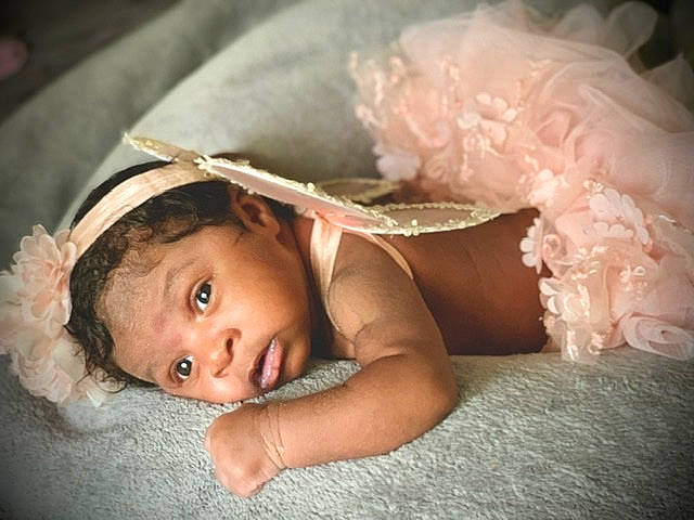 Karter is registered to the contest to win money with this photo: baby, cheek, child, eye, fashion_accessory, fun, hair_accessory, hand, headgear, headpiece, iris, lip, person, photography, pink, room, skin, smile, toddler