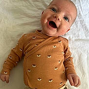 Layla joined the competition — help win amazing prizes! baby, smile, infant, clothing, cute, lying_down, patterned_clothes, fox_print, happy, child, white_background, cheerful, small_hands, face, portrait, baby_garments, indoors, young_child, cozy, playful