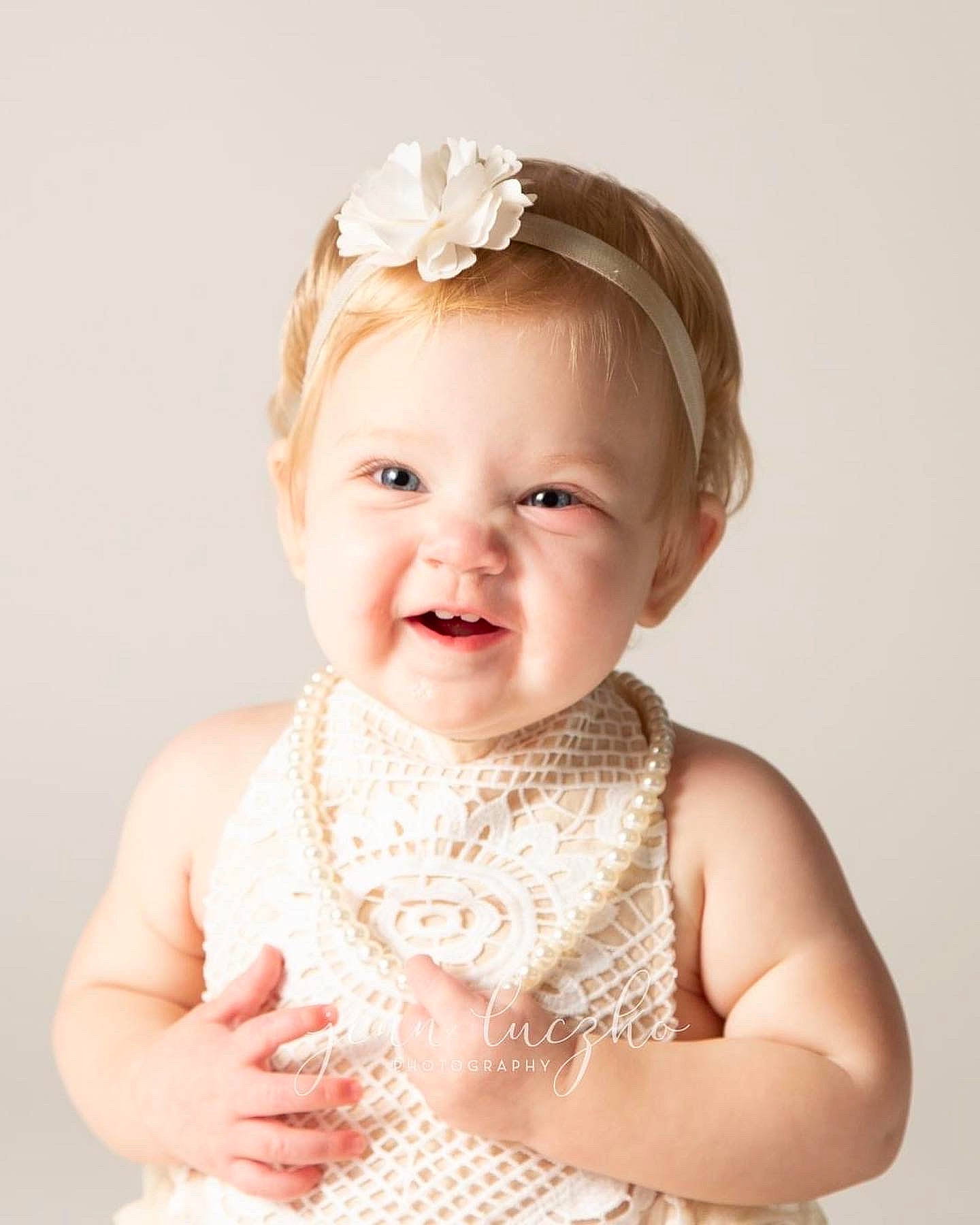 Emilia joined the competition — help win amazing prizes! baby, baby_toddler_clothing, bridal_accessory, cheek, child, dress, embellishment, face, flash_photography, happy, headband, headpiece, iris, jewellery, neck, person, pink, skin, sleeve, smile