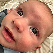 Hudson joined the competition — help win amazing prizes! baby, close_up, face, infant, curious, wide_eyes, mouth, skin, cushion, pattern, carpet, lying_down, expression, child, young, cute, indoors, portrait, human, person