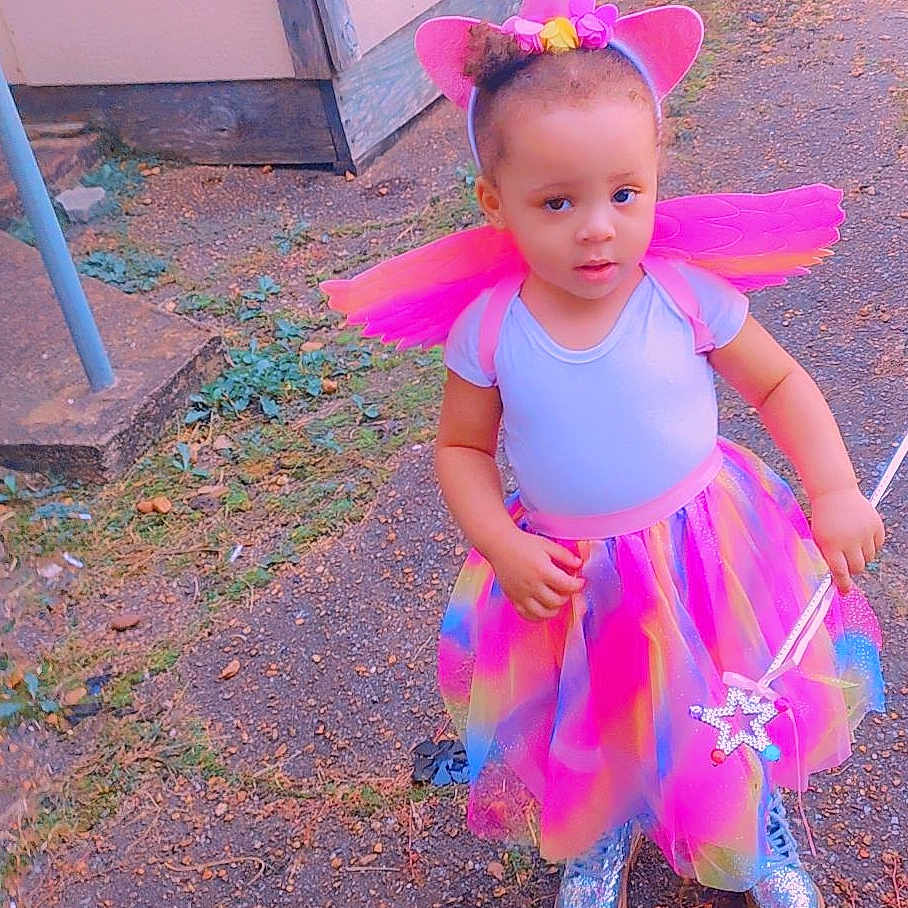 Emery is registered to the contest to win money with this photo: child, city, clothing, costume, dress, face, female, footwear, girl, grass, hat, head, person, photography, plant, portrait, purple, road, street, urban