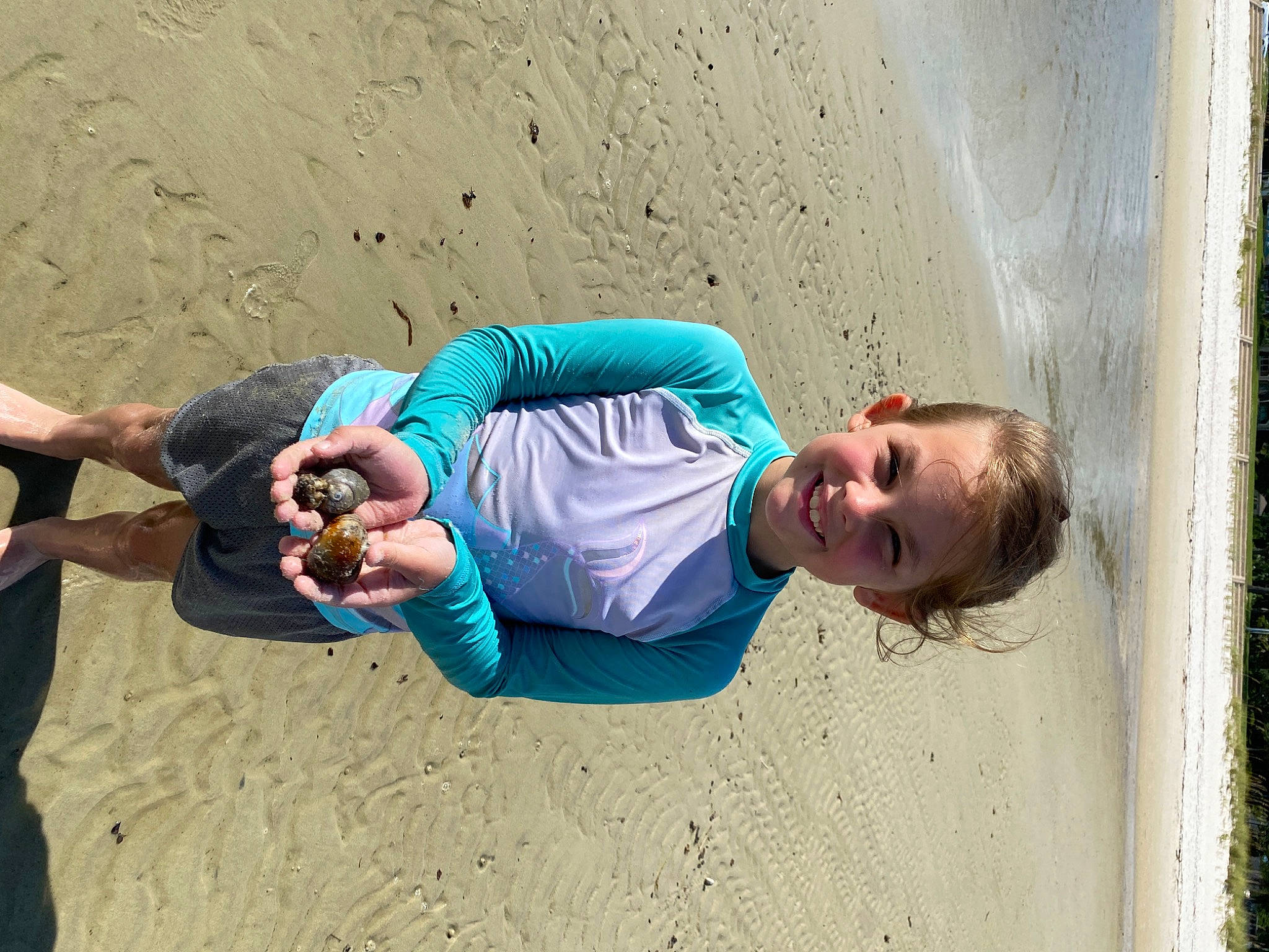 Ava-grace is registered to the contest to win money with this photo: azure, beach, body_of_water, child, concrete, electric_blue, fun, happy, joy, landscape, leisure, person, play, recreation, sand, sitting, skin, soil, t_shirt, travel