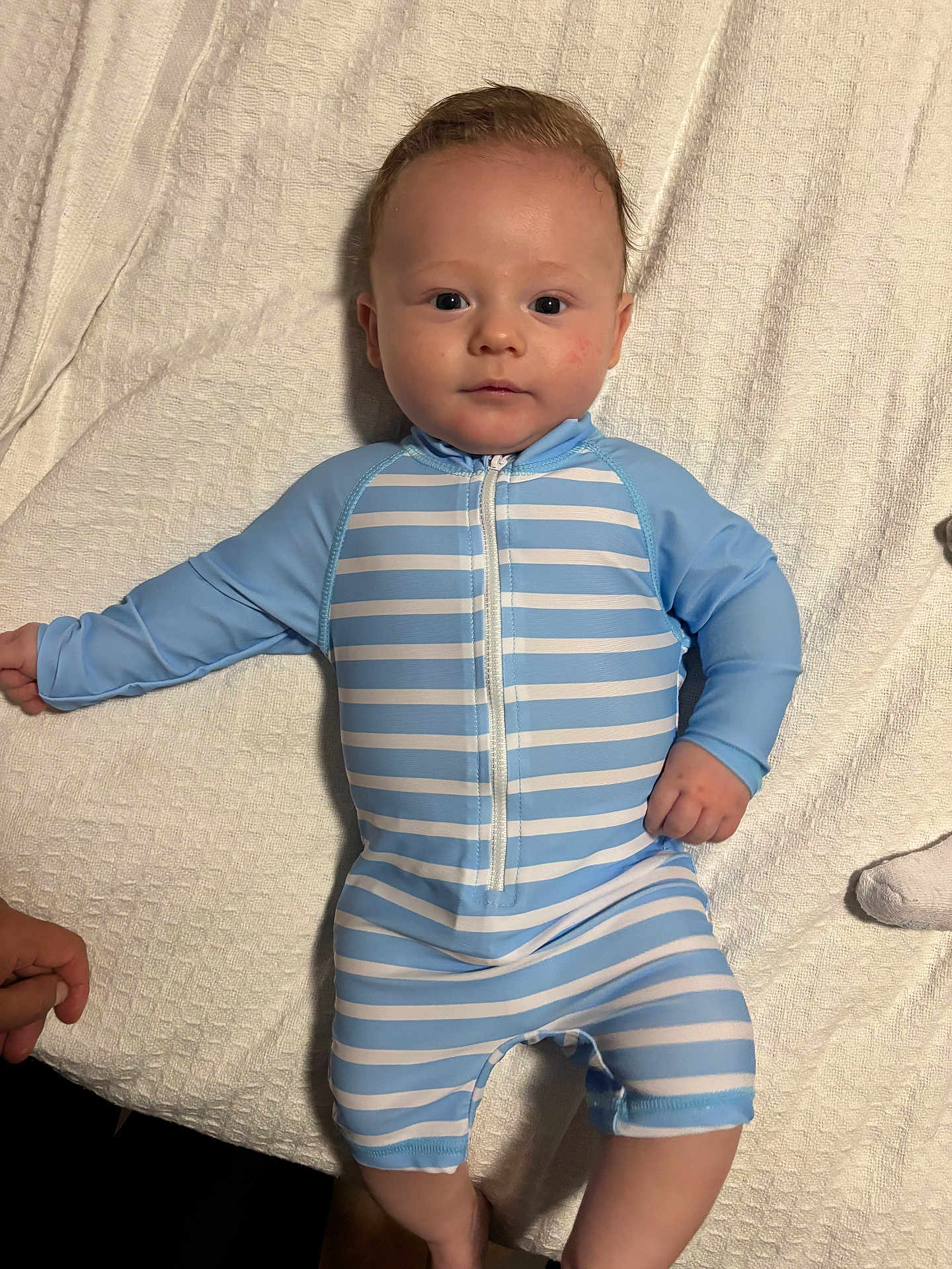 Beckett joined the competition — help win amazing prizes! baby, blanket, blue_onesie, child, cute, eyes, face, hair, hands, indoor, infant, legs, lying_down, newborn, onesie, portrait, skin, smile, striped_clothing, towel
