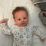 Beckett is registered to the contest to win money with this photo: baby, bed, big_eyes, blanket, cozy, curly_hair, cute, dinosaur_print, gaze, hand, indoors, infant, lying_down, newborn, onesie, pajamas, portrait, red_hair, soft_texture, waffle_texture