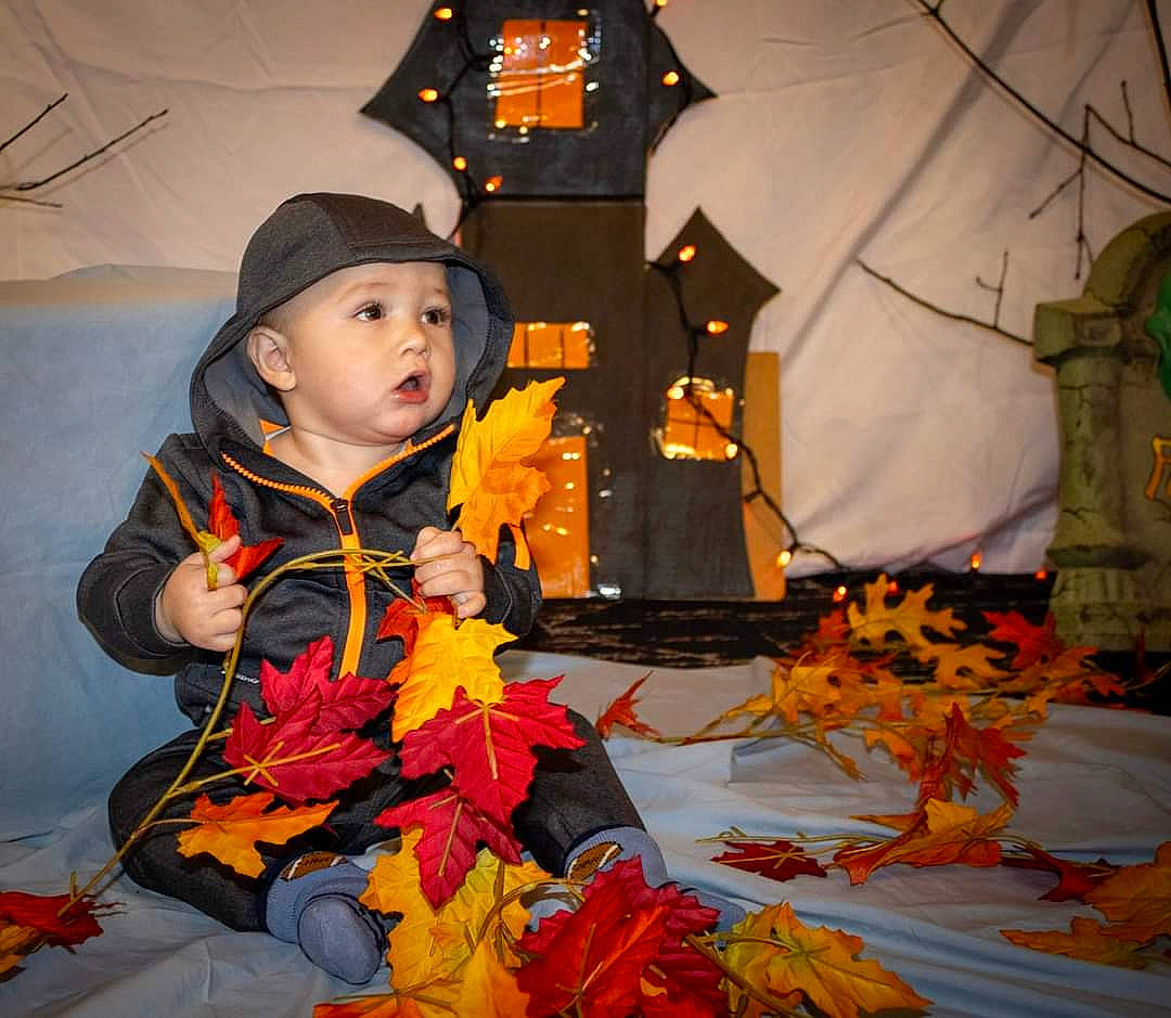 Zaiden joined the competition — help win amazing prizes! cap, costume, event, flower_arranging, flowering_plant, fun, happy, hat, headwear, holiday, hoodie, human_body, jacket, orange, person, plant, pumpkin, toddler, tradition, tree