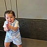 Josiah is registered to the contest to win money with this photo: toddler, child, clothing, blue_vest, shorts, white_shoes, indoor, smiling, clapping_hands, person, cute, hair, face, standing, fashion, happy, young_child, baby, casual, portrait
