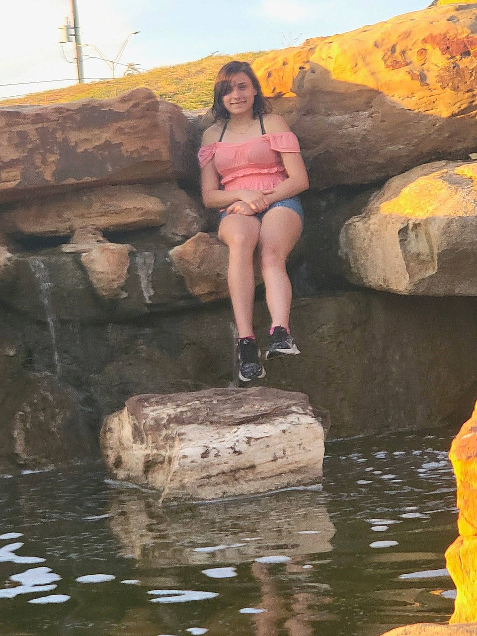 Madisyn is registered to the contest to win money with this photo: bedrock, body_of_water, coast, eye, flash_photography, formation, fun, human_leg, joy, landscape, leg, leisure, people_in_nature, person, recreation, rock, sitting, sky, stream, thigh