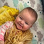 Reagan joined the competition — help win amazing prizes! baby, smiling, doll, yarn_hair, plush_toy, blanket, cloud_pattern, star_pattern, infant, child, cute, happy, soft_toy, lying_down, indoors, pink_clothing, yellow_blanket, face, person, portrait