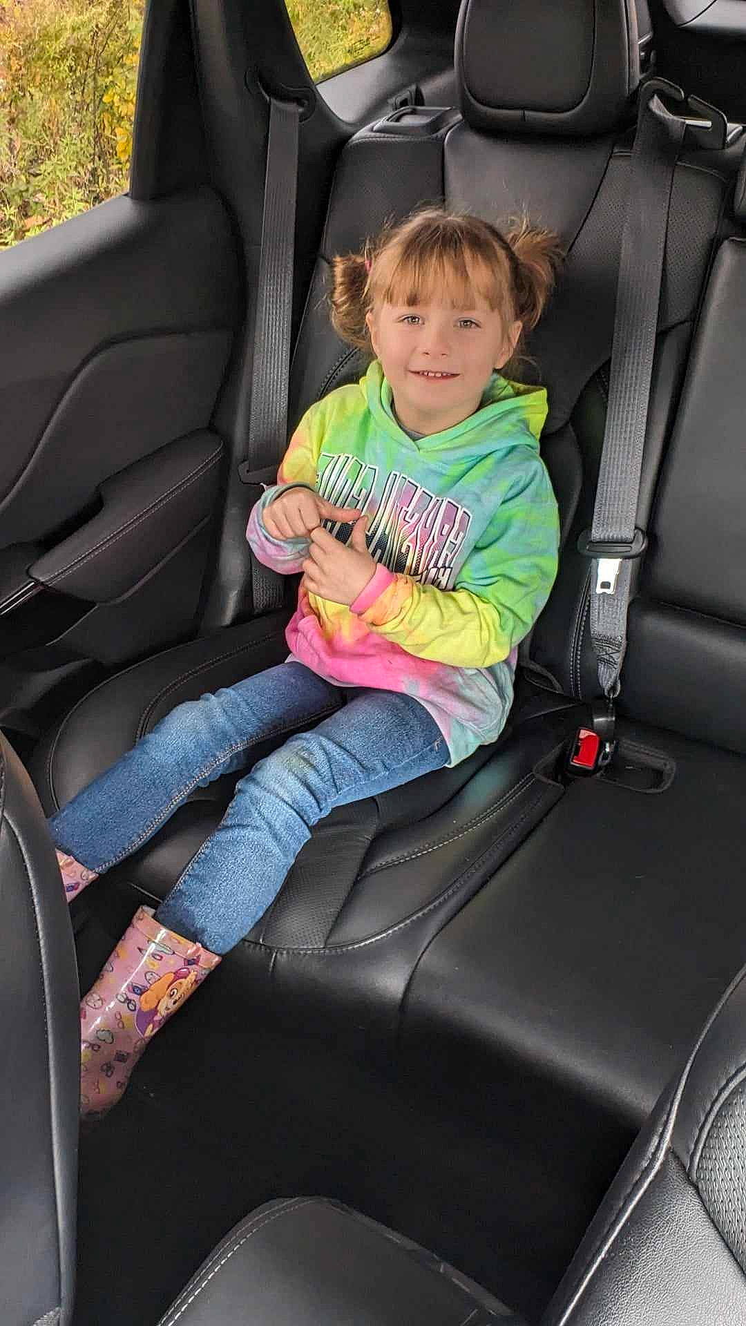 Khalisee is registered to the contest to win money with this photo: auto_part, automotive_design, automotive_exterior, car, car_seat, car_seat_cover, comfort, face, head_restraint, jeans, joy, leg, mode_of_transport, motor_vehicle, person, seat_belt, smile, steering_part, steering_wheel, toddler