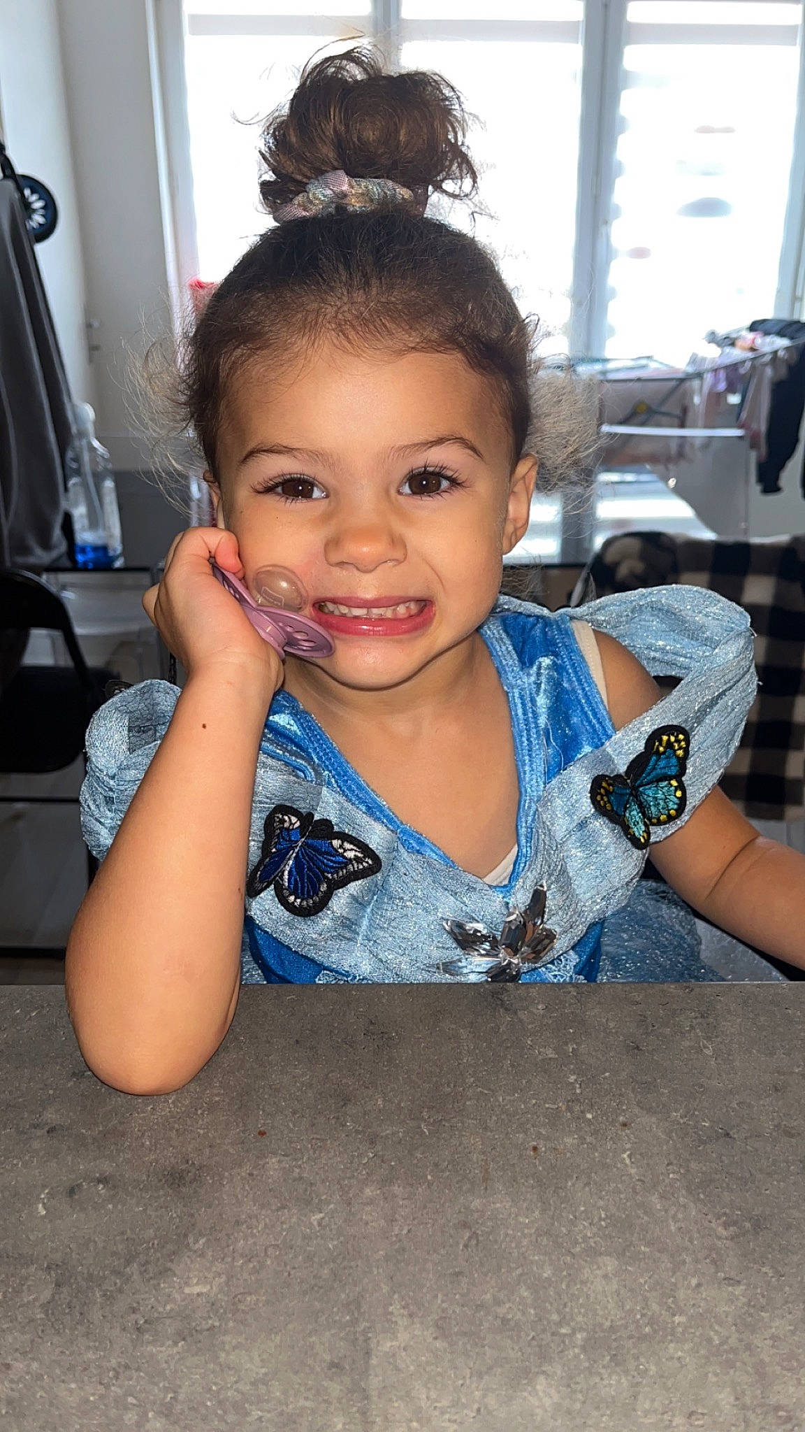 Layla a rejoint le concours — aidez-le/la à gagner de superbes lots ! asphalt, black_hair, cheek, child, electric_blue, eyebrow, eyelash, flooring, fun, hairstyle, happy, iris, jewellery, joy, person, sitting, smile, soil, t_shirt, toddler