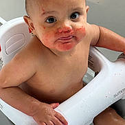 Gian is registered to the contest to win money with this photo: baby, child, bath, water, seat, skin, hand, face, eyes, mouth, messy, red_stains, curious, sitting, indoor, person, young, cute, expression, wet