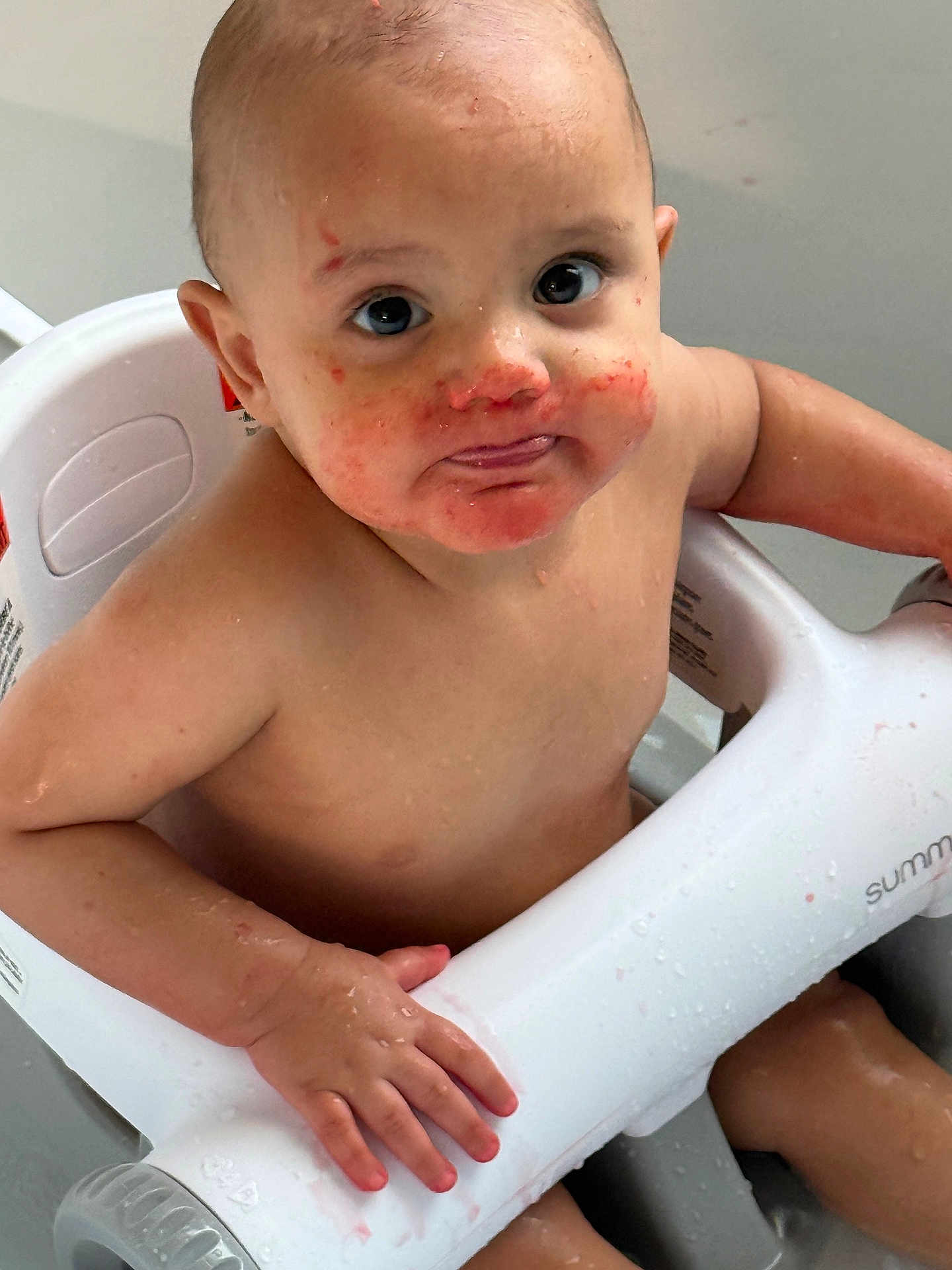 Gian is registered to the contest to win money with this photo: baby, child, bath, water, seat, skin, hand, face, eyes, mouth, messy, red_stains, curious, sitting, indoor, person, young, cute, expression, wet