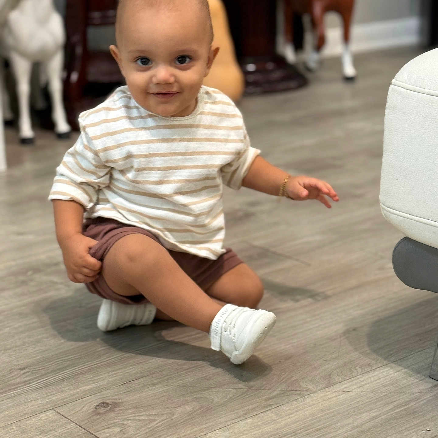Gian joined the competition — help win amazing prizes! baby, bracelet, child, cute, face, flooring, happy, home, indoor, person, playful, shorts, sitting, smiling, striped_shirt, toddler, toy_horses, white_shoes, wooden_floor, young