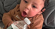 Chozen joined the competition — help win amazing prizes! baby, bed, blanket, brown_clothing, child, comfort, cozy, curious, curly_hair, cute, expression, holding, indoor, person, pillow, resting, sitting, toddler, water_bottle, young_child