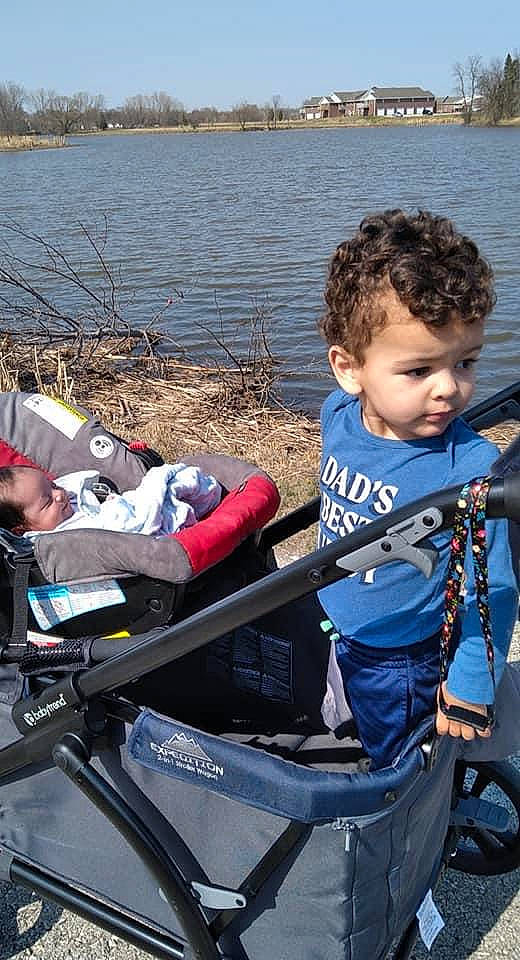 Johnathon joined the competition — help win amazing prizes! baby_carriage, baby_products, boats_and_boating_equipment_and_supplies, child, fun, lake, lap, leisure, oar, outdoor_recreation, person, personal_protective_equipment, recreation, sitting, sky, toddler, tree, vehicle, water, watercraft