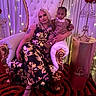 Nyuri joined the competition — help win amazing prizes! blonde_hair, carpet, child, cozy_clothing, decor, elegant, event, fairy_lights, fashion, floral_dress, indoor, metal_stand, people, portrait, purple_lighting, red_roses, seated, throne_chair, toddler, woman