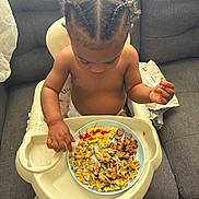 Nyuri is registered to the contest to win money with this photo: baby, braided_hair, child, couch, diaper, eating, feeding, food, gray_furniture, high_chair, indoor, ketchup, meal, messy, person, plate, sausage, scrambled_eggs, tableware, toddler