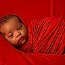 baby, infant, red_cloth, wrapped, portrait, face, newborn, cute, soft_texture, blanket, closeup, sleepy, warm, child, skin, expression, head, lying_down, cozy, comfort
