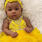 Maci Brown joined the competition — help win amazing prizes! baby, child, yellow_dress, headband, flower, fluffy_background, infant, portrait, cute, smiling, fashion, adorable, young_child, laying_down, bright_colors, close_up, person, happy, innocent, soft_texture