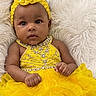 baby, child, yellow_dress, headband, flower, fluffy_background, infant, portrait, cute, smiling, fashion, adorable, young_child, laying_down, bright_colors, close_up, person, happy, innocent, soft_texture