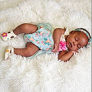 Maci is registered to the contest to win money with this photo: baby, sleeping, infant, floral_dress, headband, shoes, blanket, soft_texture, cozy, cute, peaceful, resting, child, adorable, portrait, indoors, lying_down, newborn, comfort, sleep