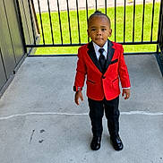 Kingston joined the competition — help win amazing prizes! child, boy, red_blazer, black_tie, formal_wear, concrete_floor, black_shoes, fence, green_grass, outdoor, portrait, standing, confident, young_child, short_hair, watch, daylight, casual_background, black_pants, fashion