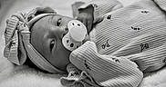 Lou a rejoint le concours — aidez-le/la à gagner de superbes lots ! baby, black_and_white, blanket, bow_headband, close_up, cozy, eyes, face, floral_pattern, hand, hat, infant, lying_down, newborn, onesie, pacifier, portrait, sleepwear, soft_texture, striped_clothing
