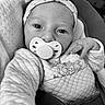 baby, black_and_white, blanket, bow, buckle, car_seat, close_up, clothing, cozy, eyes, hand, headband, infant, newborn, onesie, pacifier, portrait, quilted, seat, skin