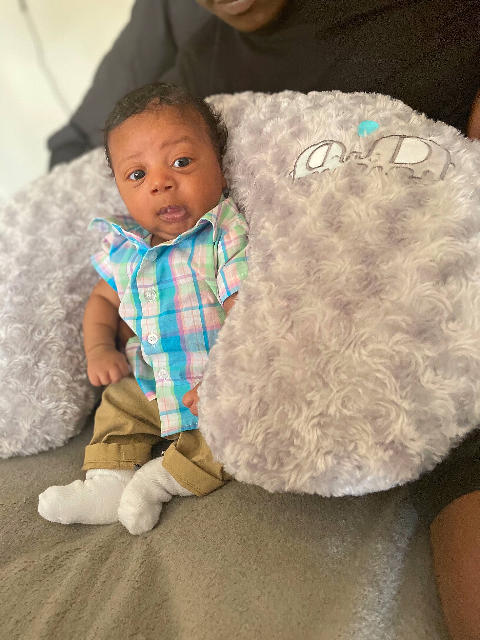 Zakai is registered to the contest to win money with this photo: baby, baby_toddler_clothing, child, comfort, costume_hat, couch, fur, hat, linens, pattern, person, plaid, room, sitting, sleeve, stuffed_toy, tartan, textile, throw_pillow, toddler